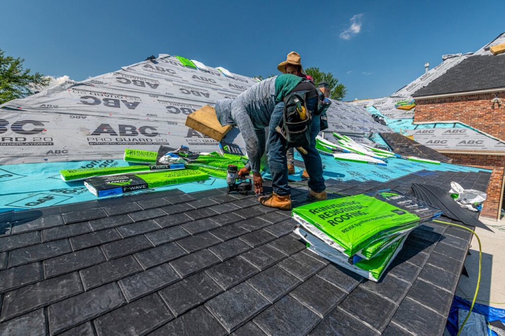 Workers installing a synthetic slate roof on a brick house in Fort Worth, Texas.